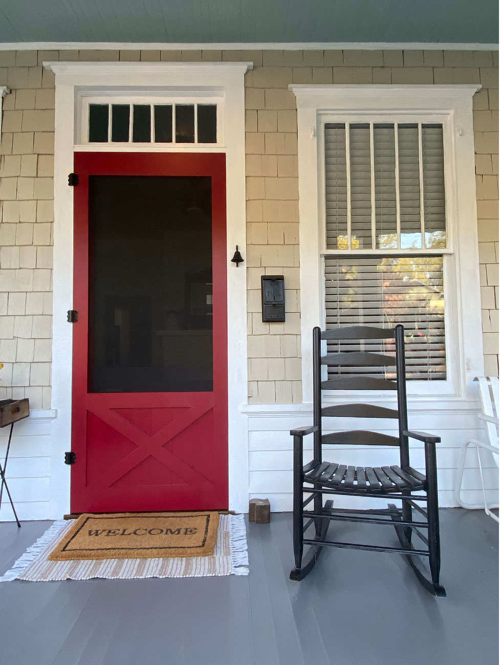 Red screen door on front porch of historic home.