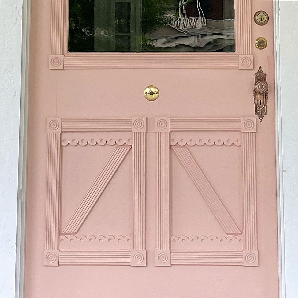Pink front door with vintage hardware.